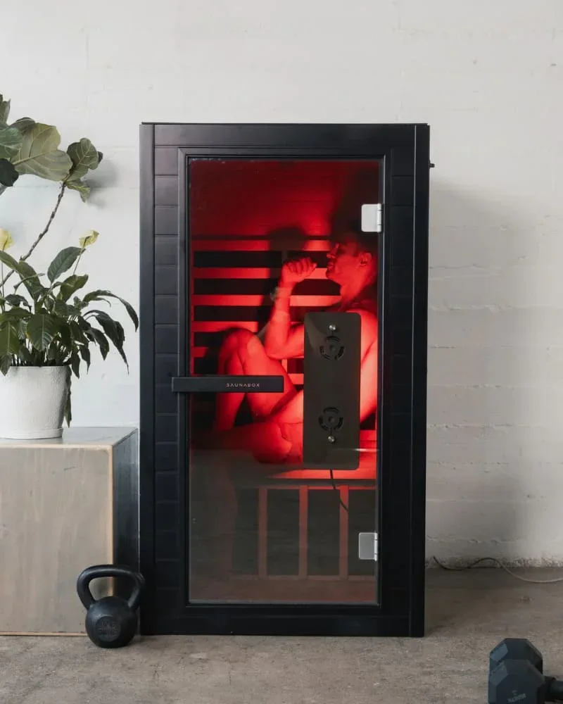 Man using SaunaBox Solara infrared sauna, seated inside while enjoying red light therapy session