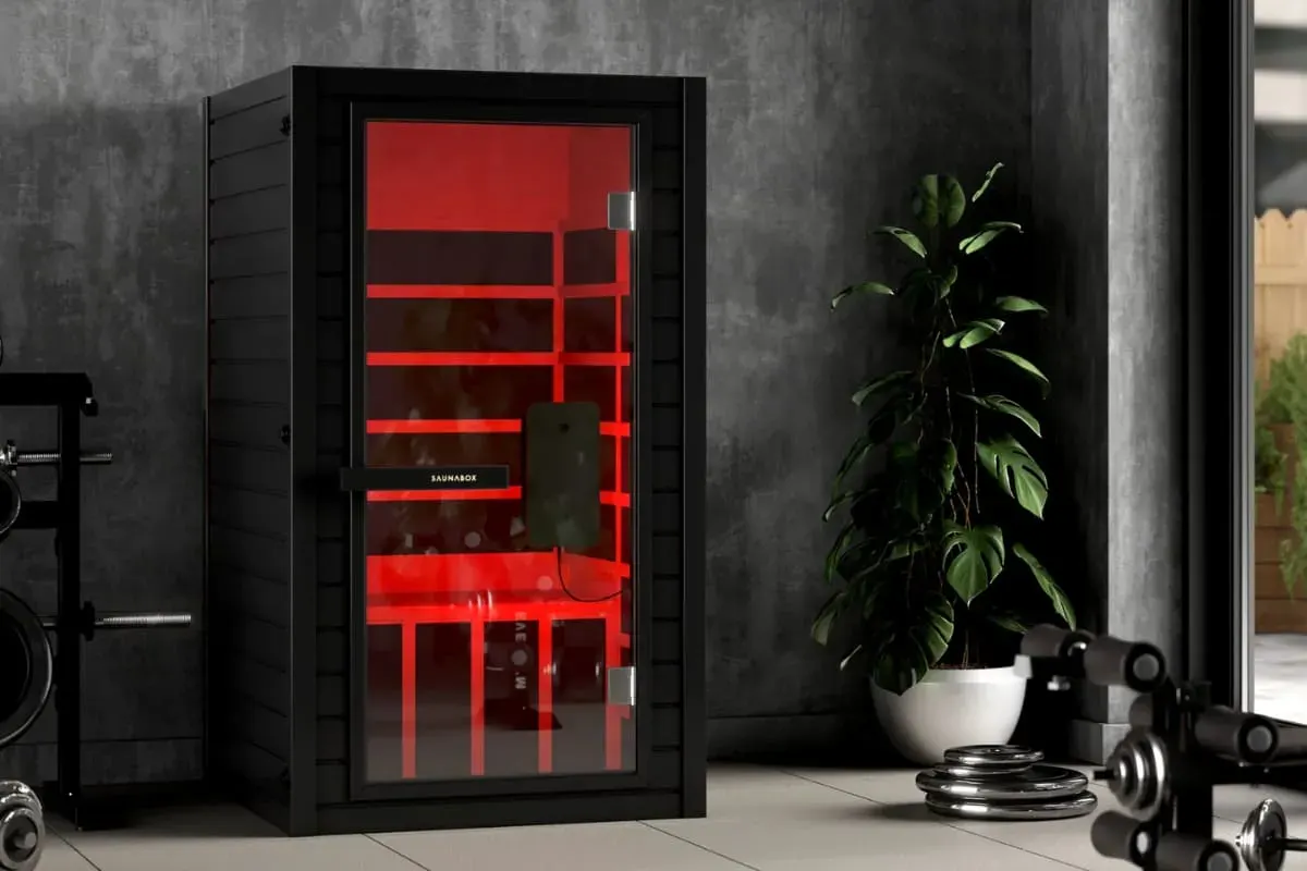 SaunaBox Solara full-spectrum infrared sauna with red light therapy in a modern home gym setting